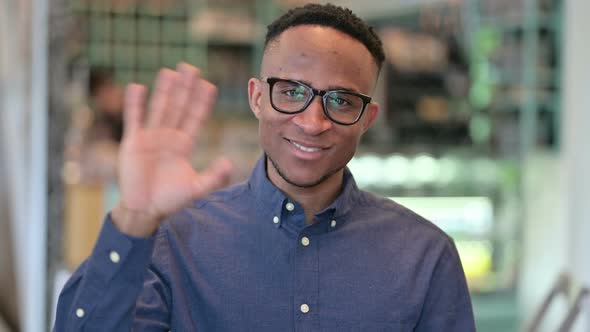 Cheerful African Man Waving at the Camera 