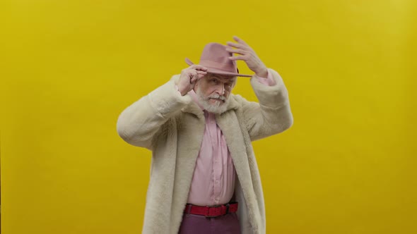 Stylish Old Man In Pink Clothes On Yellow Background