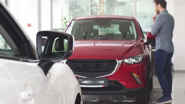 Mature Man Choosing a New Car at the Dealership Salon