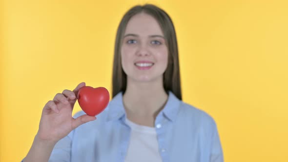 Young Woman Holding Red Heart Shape, Yellow Background