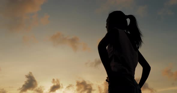 Silhouette of woman with seascape in the sunset time 