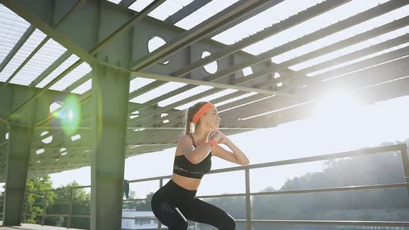 Sporty Slender Young Woman which Doing Squat Exercises Outdoors