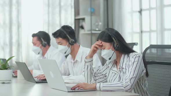 A Woman Of Three Asian Call Centre Agents Wearing Mask And Headache To Work