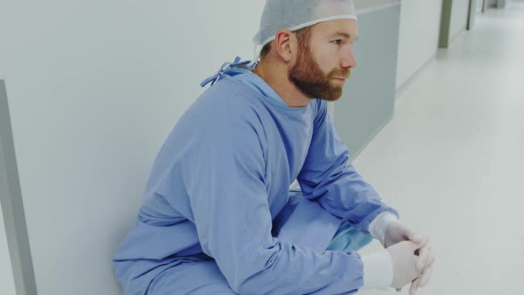 Side view of worried Caucasian male doctor walking in the corridor