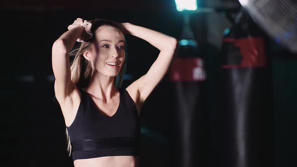 Attractive Fit Girl with Flowing Hair Smiles at Camera on Fan Background