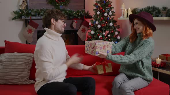 Loving couple exchanging gifts