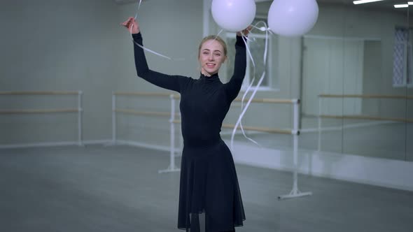 Gorgeous Slim Young Ballerina Performing Pirouette with Balloons Smiling Looking at Camera