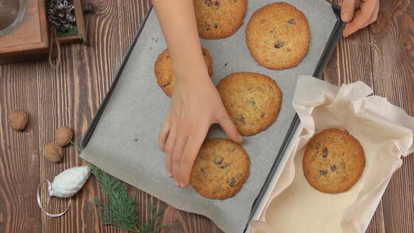 Female Hand Takes Oatmeal Coockies From a Pan and Puts It Into Christmas Box