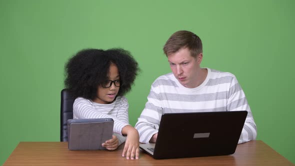 Young African Girl and Young Scandinavian Man Using Gadgets Together