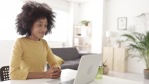 Young African Woman Doing a Video Call on Laptop in the Living Room at Apartment