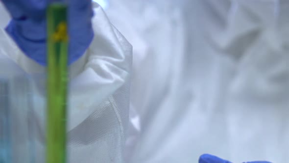 Scientist Putting Radioactive Liquid in Tube Rack, Weapons of Mass Destruction