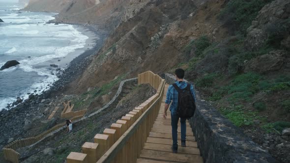 Young Man Tourist Goes Down the Long Stairs to the Famous Volcanic Black Sand Beach Benijo in the