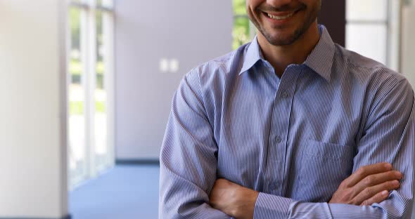 Male business executive standing with arms crossed in office 4k