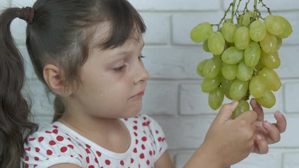 The kid eats grapes.  alt
