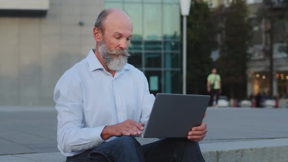 Serious Ponder Pensioner Writer Creative Worker Sitting Outdoors Using Laptop Works Remotely Online