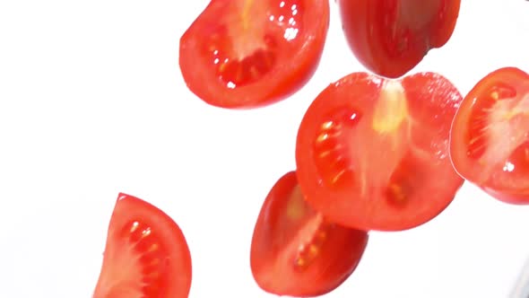 Closeup of the Fresh Tomato Halves Falling Diagonally on a White Background