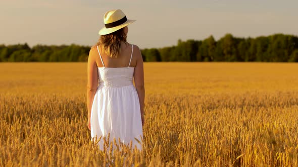 Woman in Straw Hat on Cereal Field in Summer