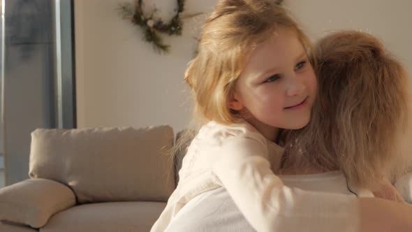 Daughter rushes into mother's arms at home and gives her a big hug.