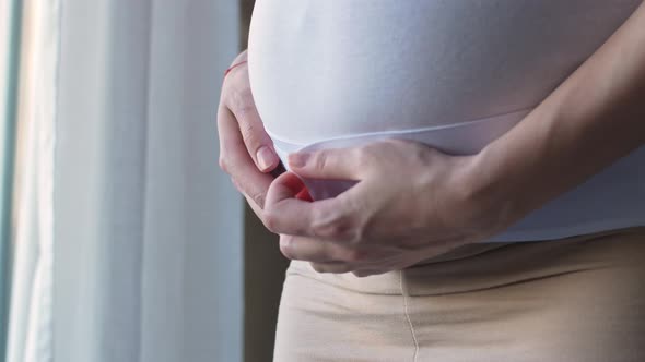 Bandage for pregnant women. Girl puts on a bandage for pregnant women.