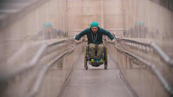 Disabled Man in Wheelchair Getting Up on the Long Special Ramp Leaning on the Railing