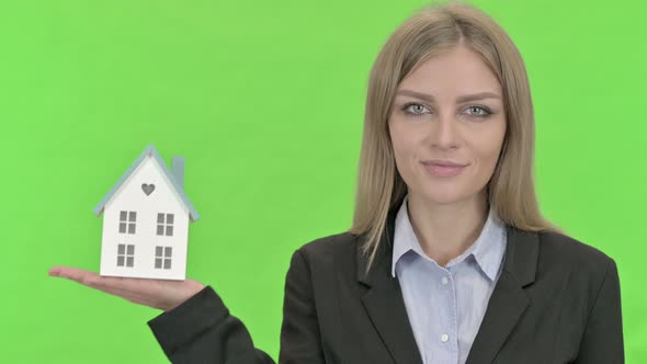 Cheerful Businesswoman Holding Model House Against Chroma Key