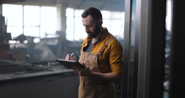 Worker Checking the Quality of Metal Products with a Digital Tablet