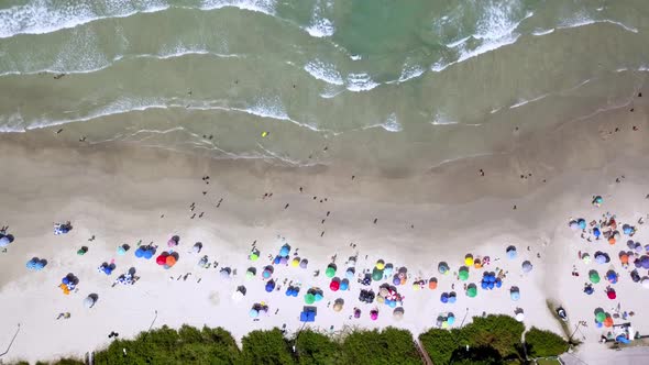 Aerial top down shot of the sea on the upper side and Bombinhas beach on the bottom