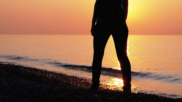 Silhouette of a Woman at Sunset Running Along the Seashore