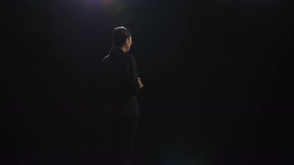 Asian Speaker Woman In Business Suit Holding Her Hands Together In The Black Screen Studio