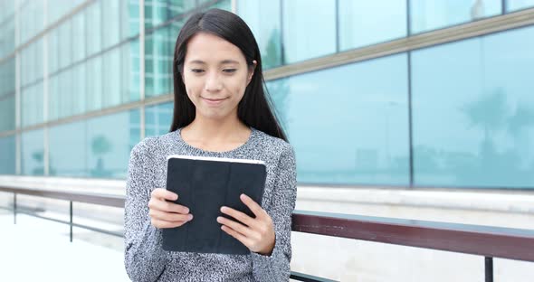 Young woman use of digital tablet in city