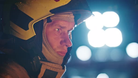 Portrait Shot of a Fireman in Action in Full Uniform with Bright Light in the Background