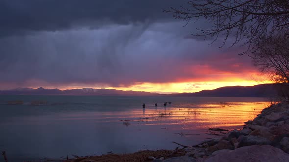 Rain storm over Utah Lake as sunset fades looking towards fishermen
