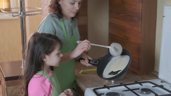The family bakes pancakes. 