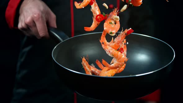 Super Slow Motion Shot of Chef Holding Frying Pan and Falling Shrimps at 1000Fps