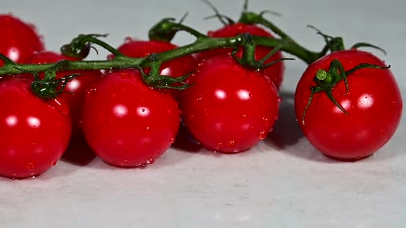 Red wet washed cherry tomatoes on table