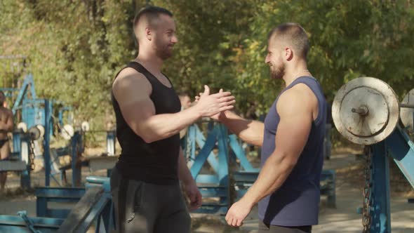 Brutal Fit Men Greeting Handshake in Outdoor Gym