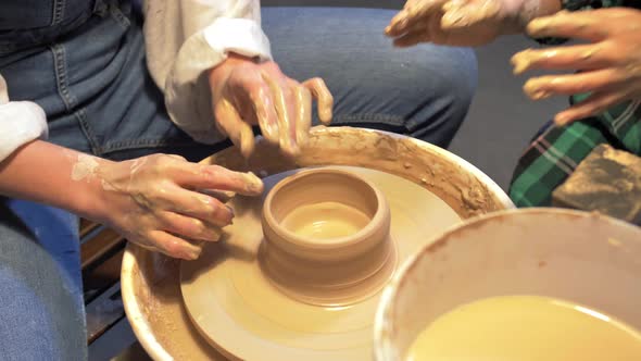 Boy and Woman Makes a Pot with Pottery Wheel in a Workshop