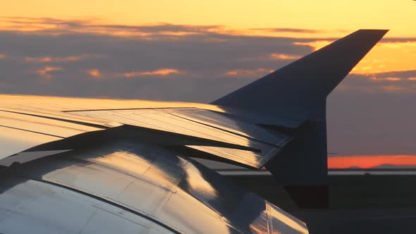 Airplane Wing On Runway At Sunset