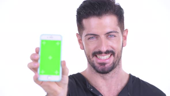 Face of Happy Young Handsome Bearded Man Showing Phone