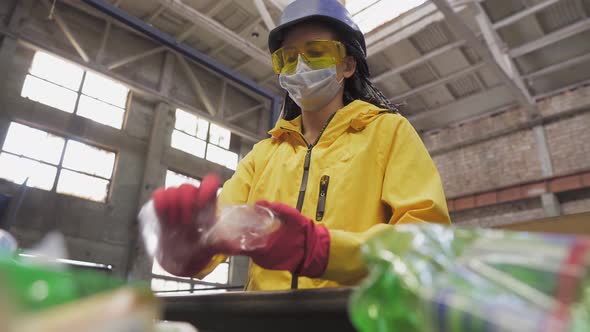 Womanvolunteer in Yellow Jacket and Transparent Protecting Glasses Hard Hat and Mask Sorting Used