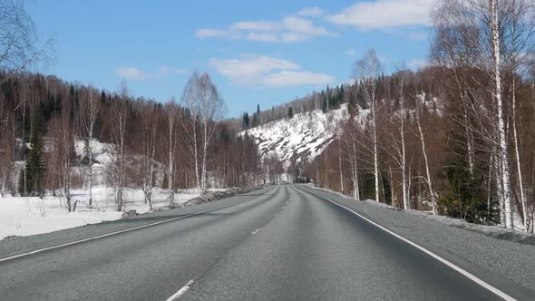 Driving On Asphalt Highway Road In Mountains Hills In Winter With Snow