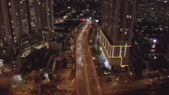 aerial view across busy traffic bridge at night. The bridge crosses a river and runs between two lar