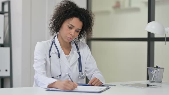 Female African Doctor Writing on Paper