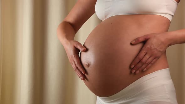 Pregnant Woman Holding and Touching her Belly