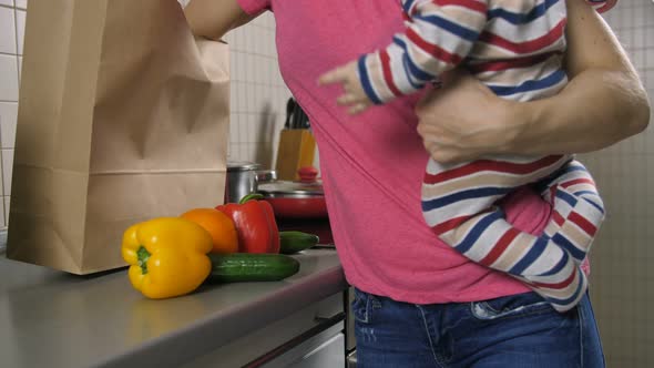 Mom's Midsection with Baby Unloading Groceries