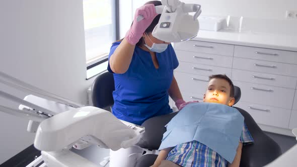 Female Dentist with Kid Patient at Dental Clinic 