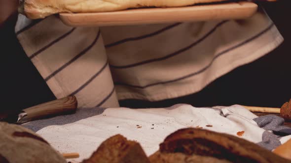 Baker Putting Freshly Made Bread on Table