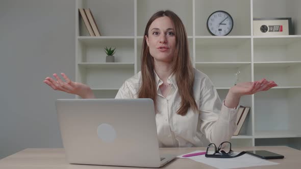 Smiling Beautiful Millennial Business Woman Sitting at Table Looking at Camera Holding Web Camera