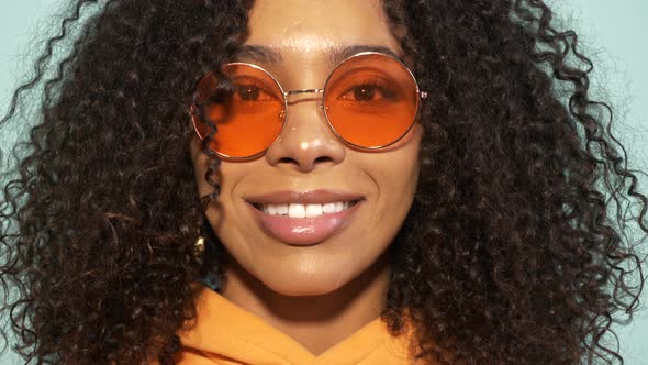 Smiling model in orange hoodie posing in studio