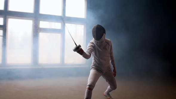 A Young Woman Fencer Showing Basic Attack Movements on the Fencing